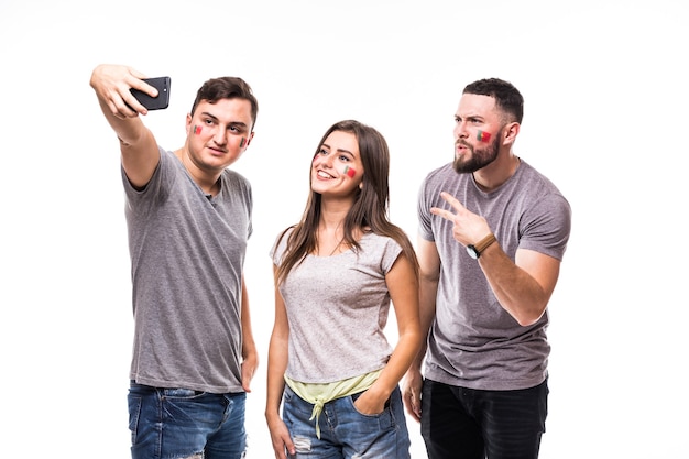 Un gruppo di appassionati di calcio prende selfie mentre supporta la squadra nazionale del portogallo su sfondo bianco. concetto di tifosi di calcio.