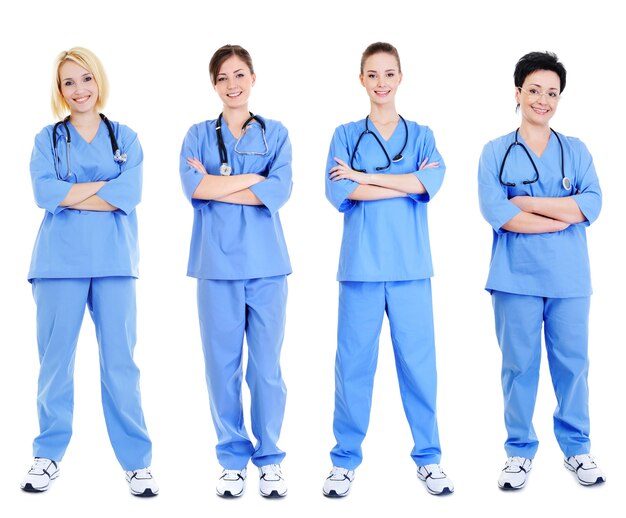 Group of four cheerful female doctors in blue uniforms isolated on white