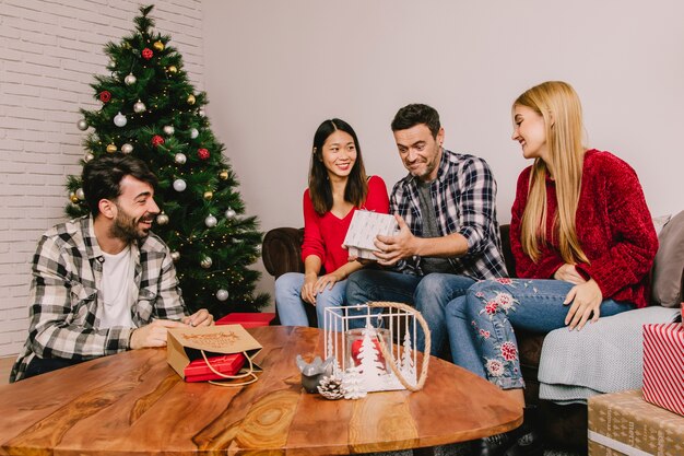 Group of four friends gifting each other