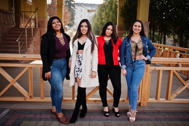 Group of four happy and pretty latino girls from Ecuador posed at street