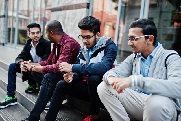 Group of four indian teen male students Classmates spend time together