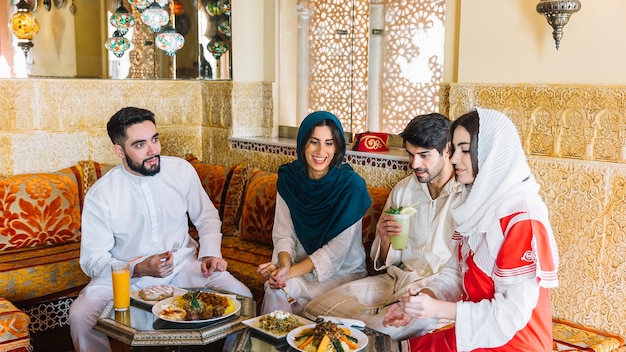 Group of four muslim friends in restaurant