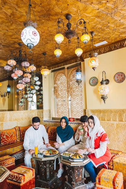 Group of four muslim friends in restaurant