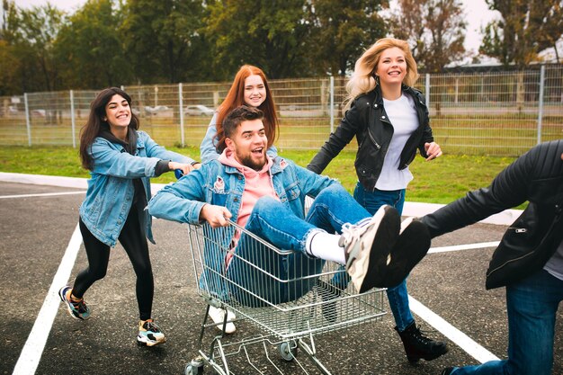 Group of four young diverse friends in jeanse outfit look carefree, young and happy on city's streets