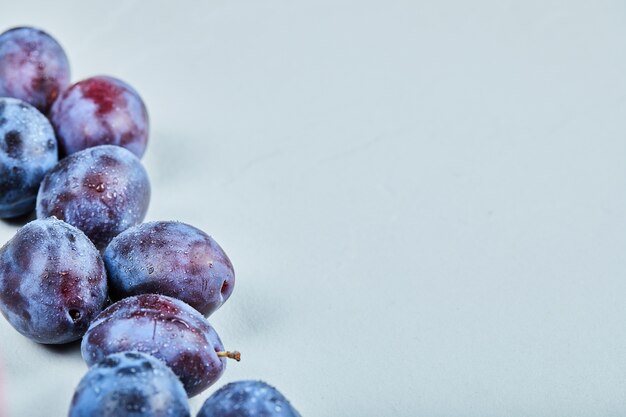 Group of fresh plums on a blue background