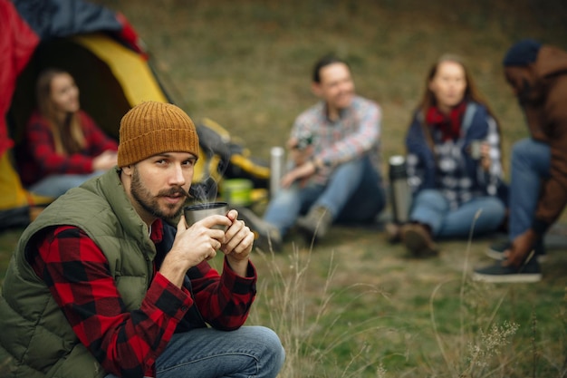 Group of friends on a camping or hiking trip in autumn day