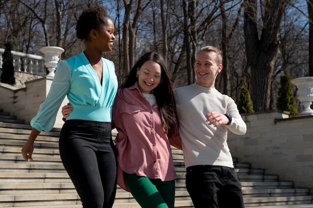 Free photo group of friends celebrating the lifting of face mask restrictions outdoors