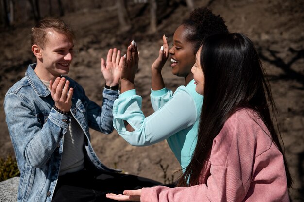 Group of friends celebrating the lifting of face mask restrictions outdoors