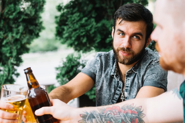 Group of friends cheering with alcoholic drinks at outdoors