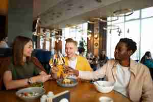 Free photo group of friends cheering with wine glasses at a restaurant