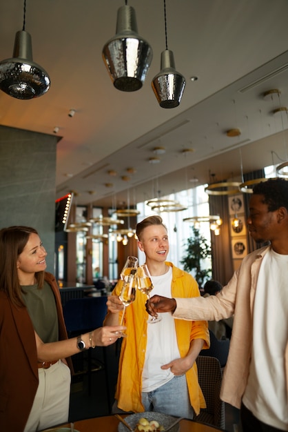 Group of friends cheering with wine glasses at a restaurant