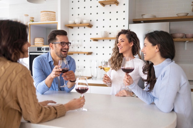 Группа друзей, пьющих вино на кухне