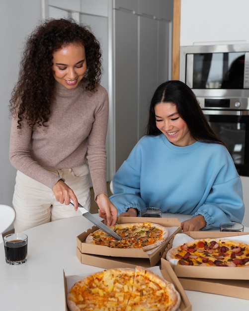 Group of friends eating pizza at home together