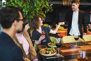 Free photo group of friends eating in restaurant