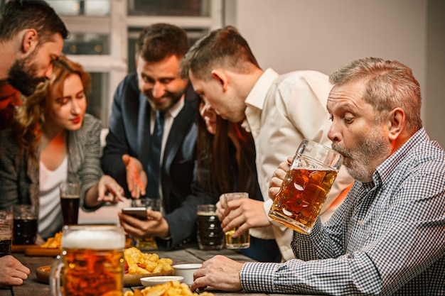 Free photo group of friends enjoying evening drinks with beer