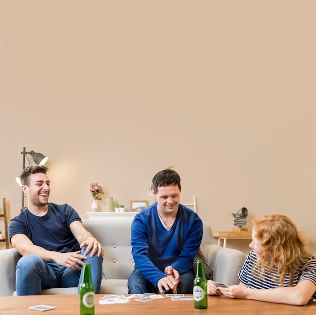 Group of friends having beer and playing cards