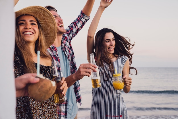 Gruppo di amici divertirsi in una festa sulla spiaggia