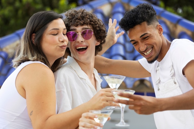 Foto gratuita gruppo di amici che si divertono durante una festa bianca con bevande