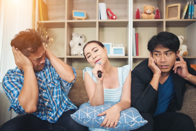 Group of friends having fun at living room singing a song together