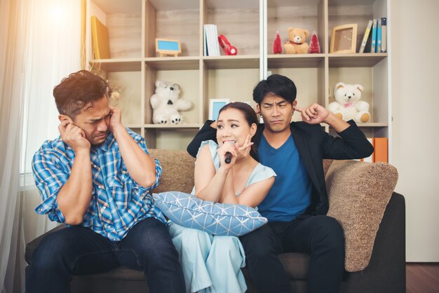 Group of friends having fun at living room singing a song together