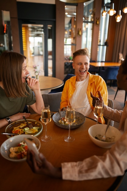 Foto gratuita gruppo di amici che pranzano insieme al ristorante