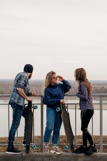 Free photo group of friends outdoors together with skateboards