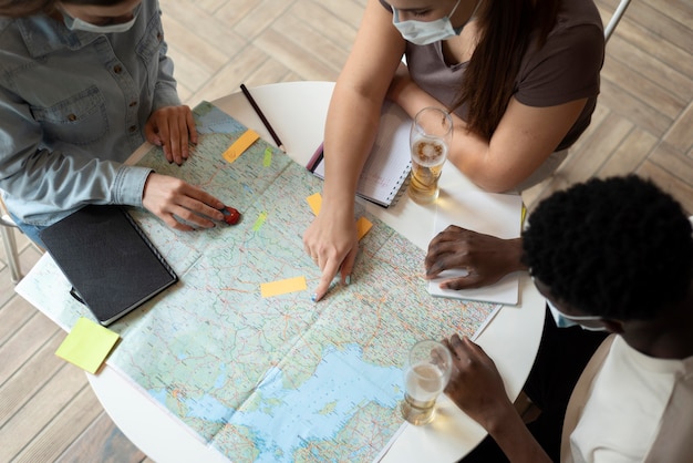 Free photo group of friends planning a trip in a cafe