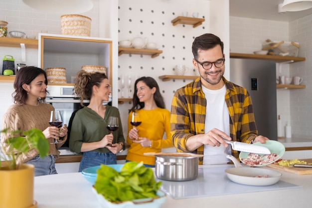 Group of friends preparing meal in the kitchen