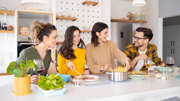 Group of friends preparing meal in the kitchen