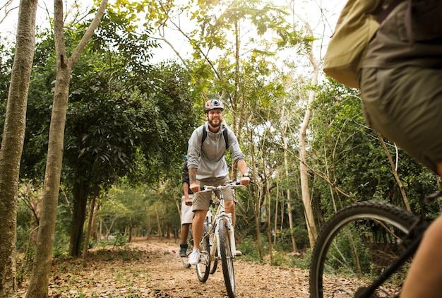 Group of friends ride mountain bike in the forest together