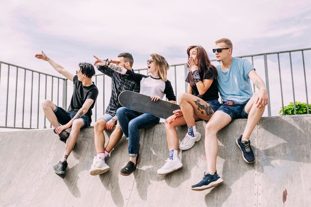 Group of friends sitting on ramp pointing at something