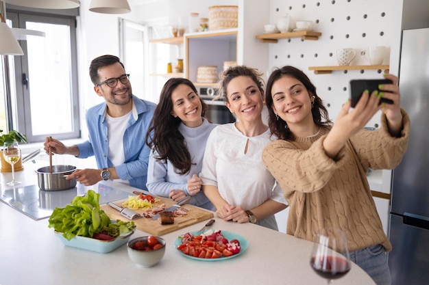 Foto gratuita gruppo di amici che prendono un selfie in cucina