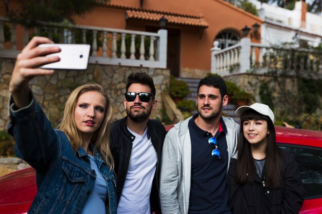 Group of friends taking selfie with mobile phone