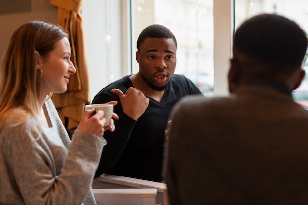 話して、コーヒーを飲む友人のグループ