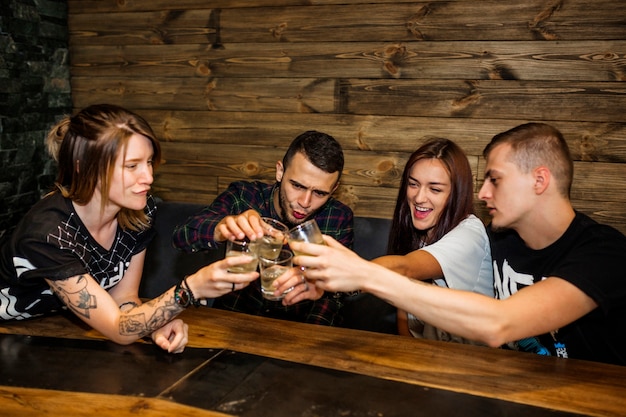 Group of friends toasting glasses of drinks at bar