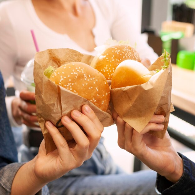 Group of friends toasting with burgers