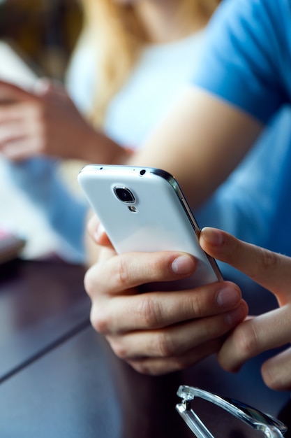 Group of friends using mobile phone in cafe.