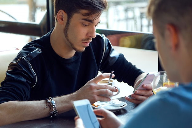 Group of friends using mobile phone in cafe.