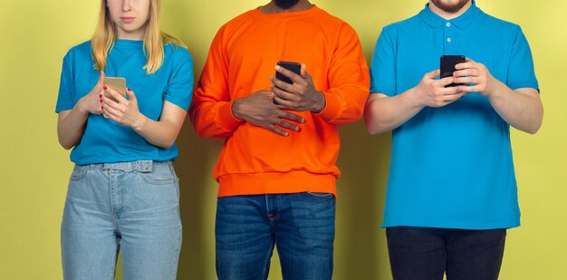 モバイルスマートフォンを使用している友人のグループ。 10代の若者が新しいテクノロジーのトレンドに依存している。閉じる。