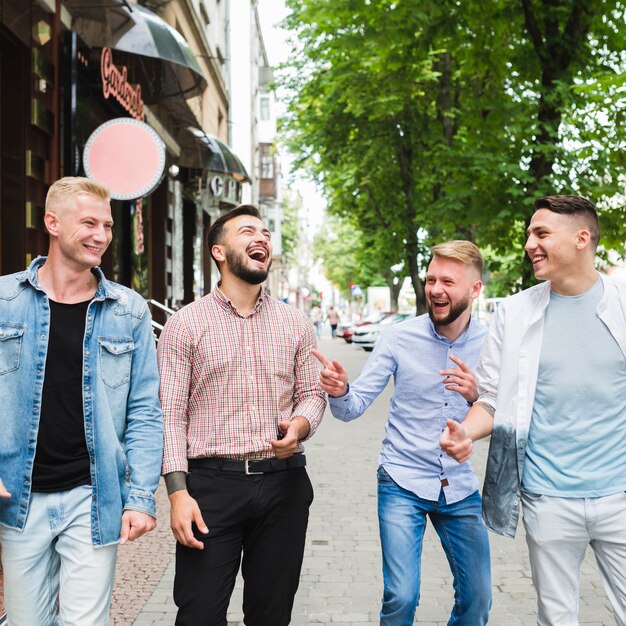 Group of friends walking down the street making fun