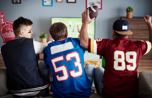 Free photo group of friends watching football at home