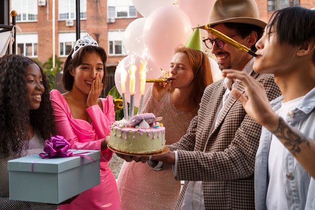 Free photo group of friends with cake at a surprise birthday party