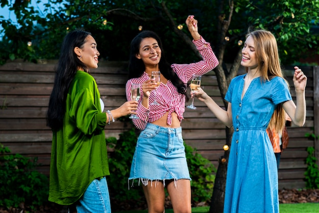 Free photo group of girls dancing together with drinks