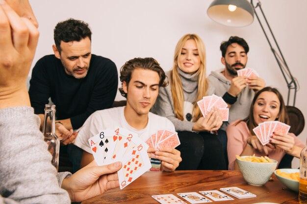 Group of good friends playing cards game