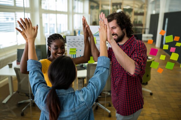 Group of graphic designers giving high five to each other