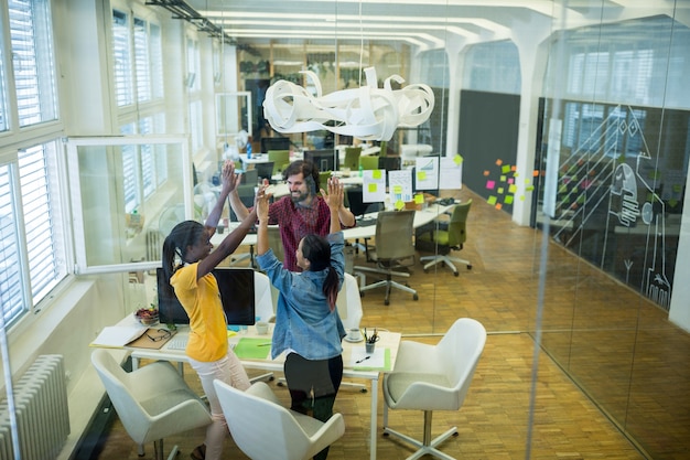 Group of graphic designers giving high five to each other