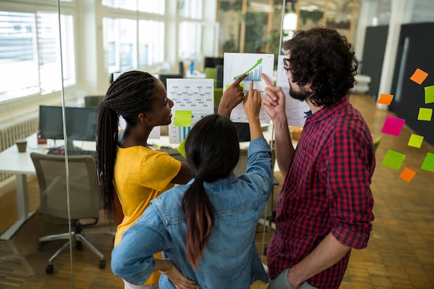 Group of graphic designers interacting over a graph