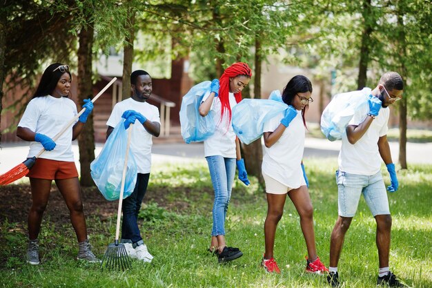 チャリティーの人々とエコロジーの概念をボランティアする公園アフリカのゴミ袋の清掃エリアを持つ幸せなアフリカのボランティアのグループ