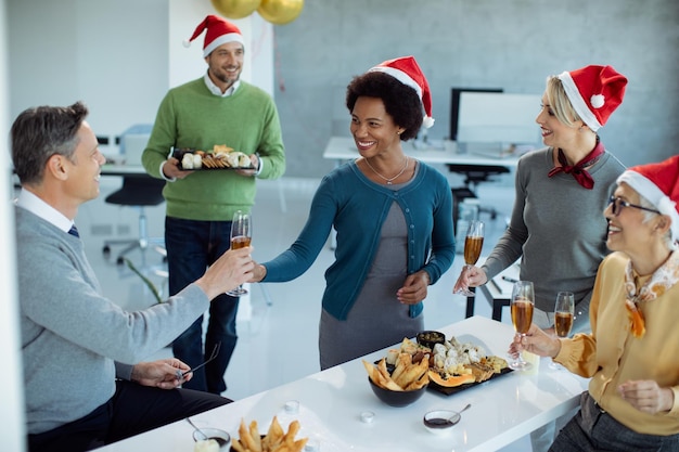 オフィスで新年会を楽しんでいる幸せなビジネスの人々のグループ