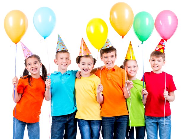 Group of happy children in colored t-shirts with balloons on a white background